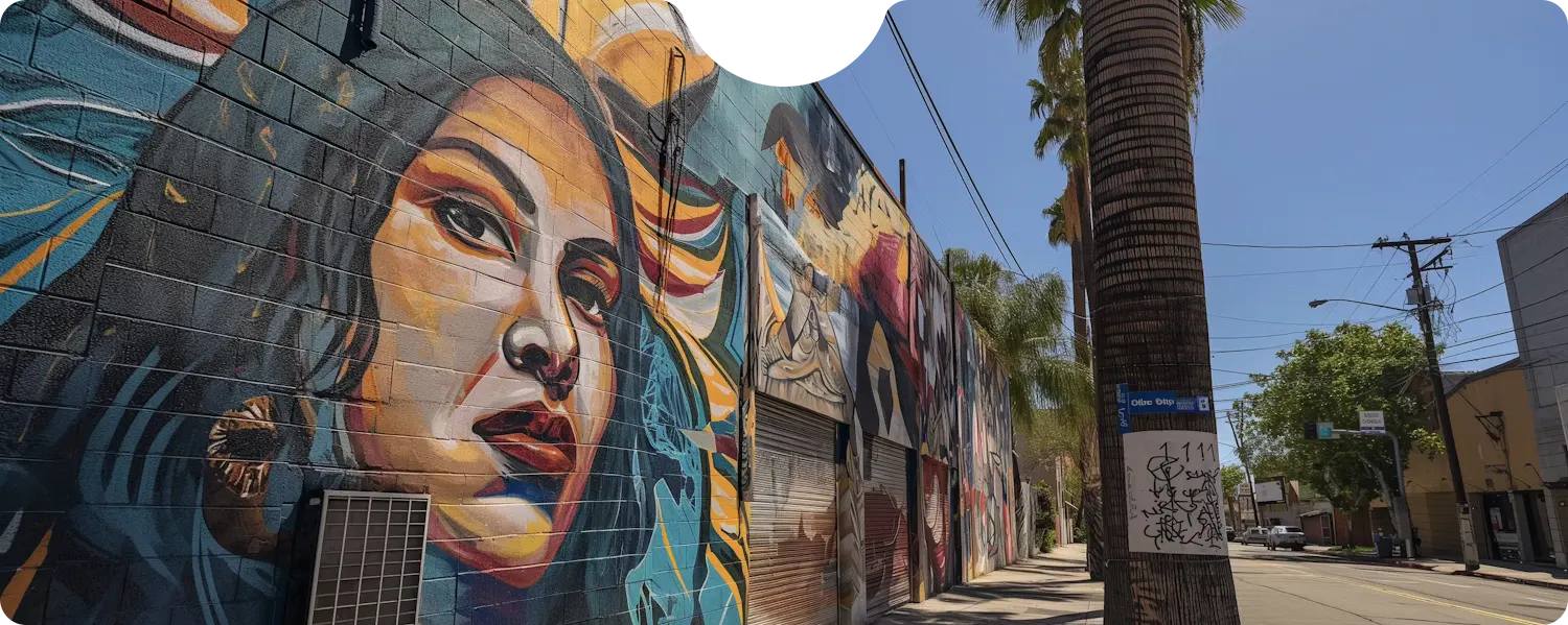 Colorful mural of a woman's face on a city wall with palm trees.